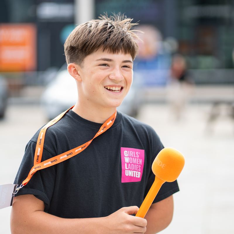 A young founder with a microphone at Busk Your Business