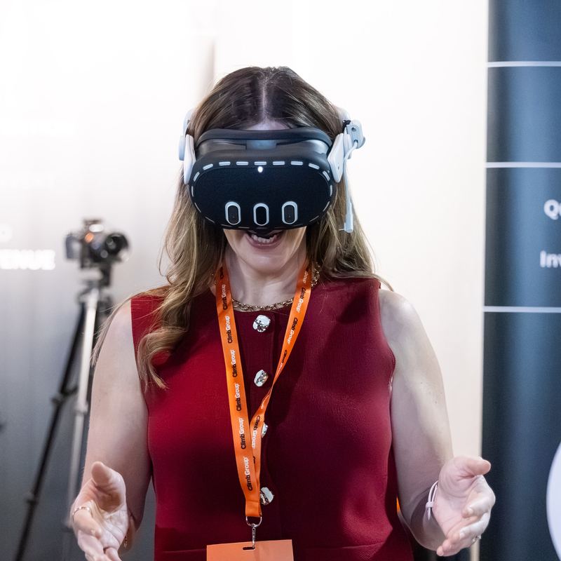 A delegate trying a VR headset on a stand