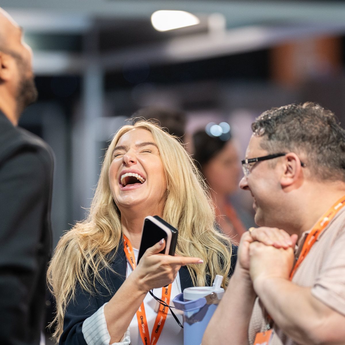 Three delegates laughing together on the expo floor