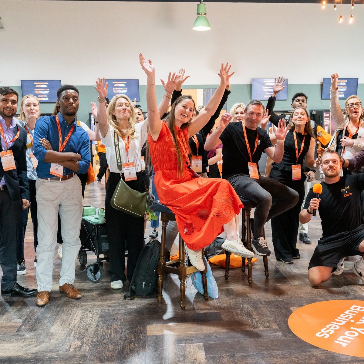 A crowd throwing their hands in the air at a Busk Your Business pitch
